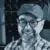 Illustration of Bjarne at his desk at Codeally. Bjarne wears a cap, glasses, a beard and a big smile.